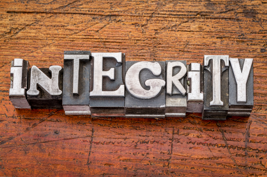 integrity word in vintage metal type printing blocks over grunge wood